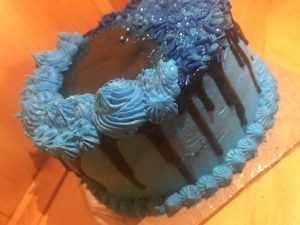 Tight crumb vanilla two tiered cake with blue and black