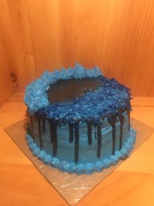 Tight crumb vanilla two tiered cake with blue and black