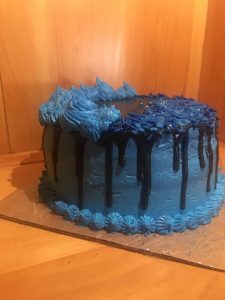 Tight crumb vanilla two tiered cake with blue and black