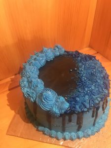 Tight crumb vanilla two tiered cake with blue and black