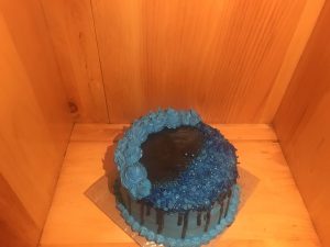 Tight crumb vanilla two tiered cake with blue and black