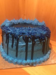 Tight crumb vanilla two tiered cake with blue and black