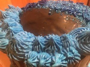 Tight crumb vanilla two tiered cake with blue and black