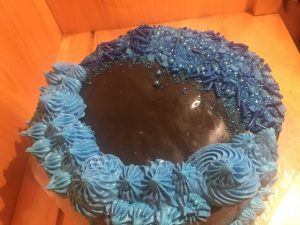 Tight crumb vanilla two tiered cake with blue and black